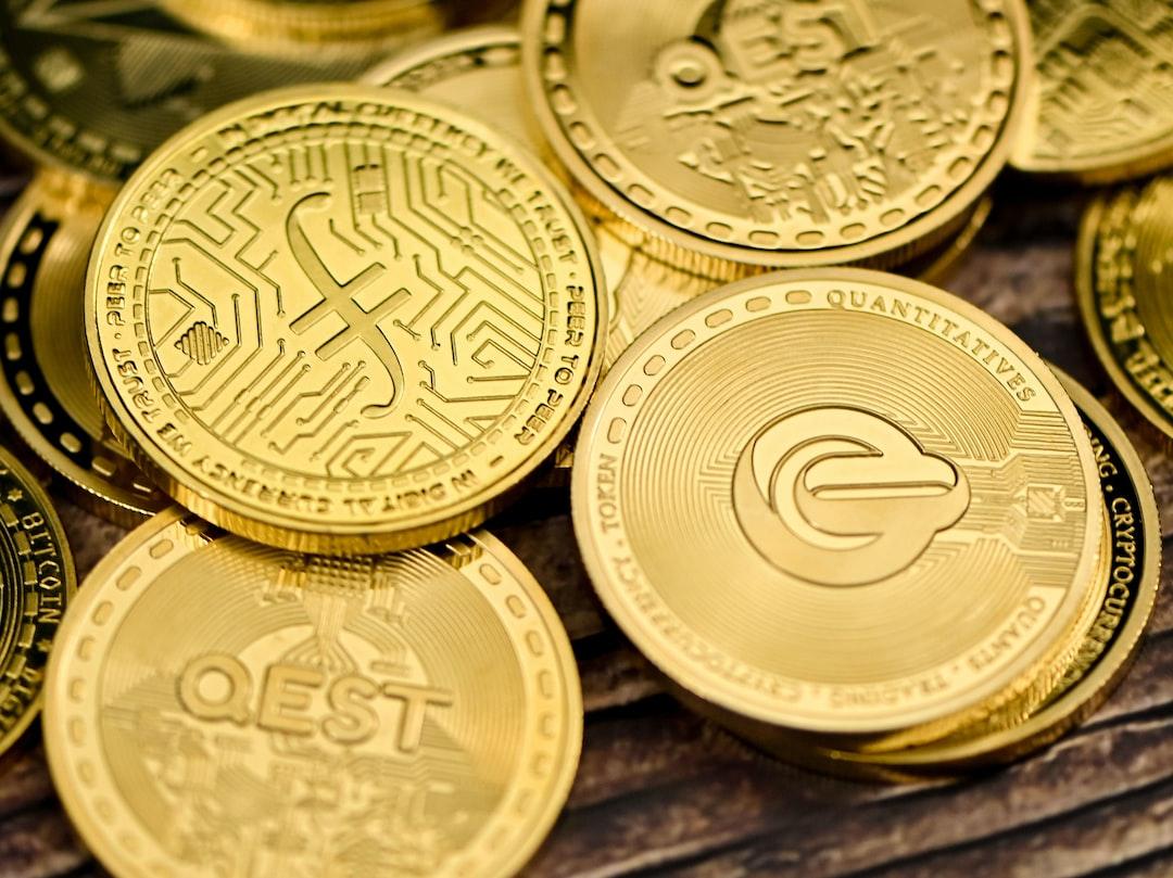 a pile of gold coins sitting on top of a wooden table - A Filecoin placed on QEST coins - unsplash